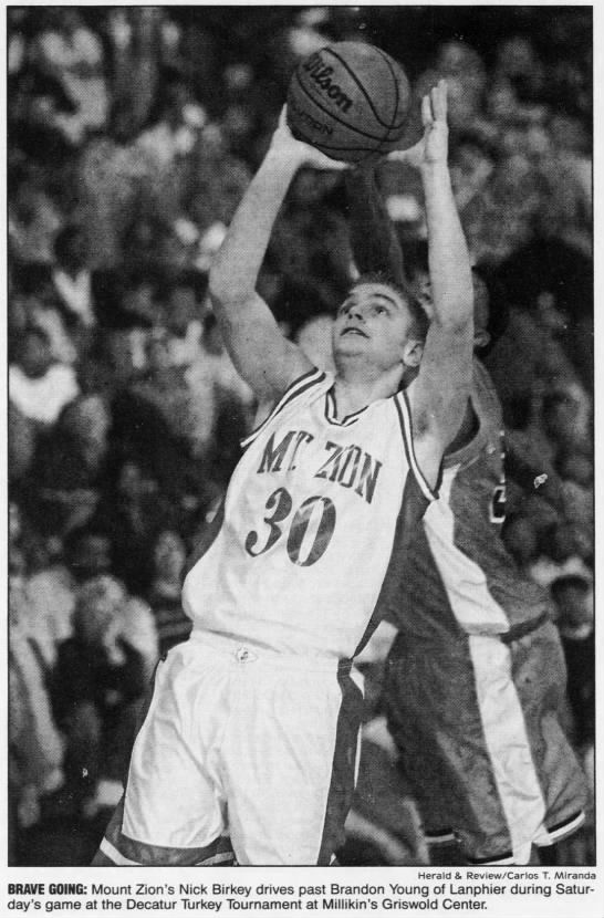 Mt. Zion's Nick Birkey drives past Brandon Young of Lanphier